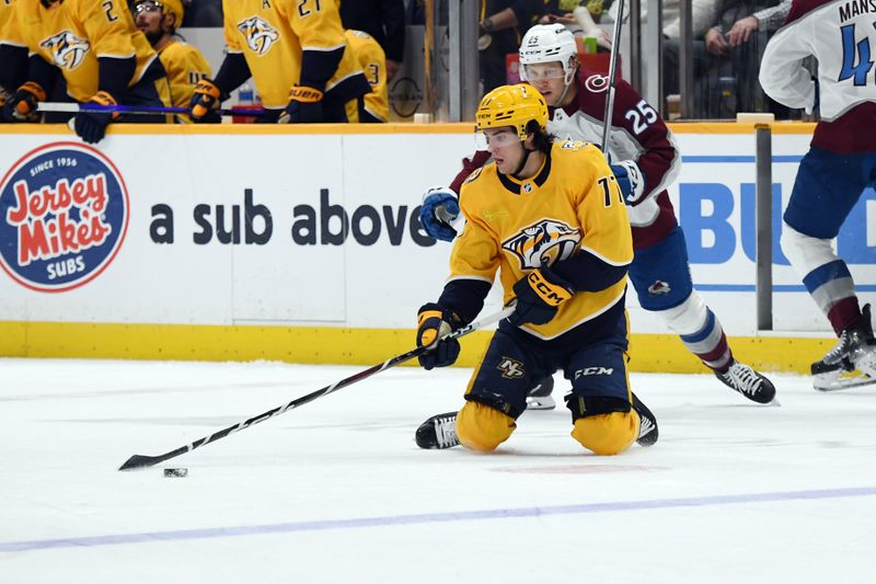 Mar 2, 2024; Nashville, Tennessee, USA; Nashville Predators right wing Luke Evangelista (77) handles the puck from his knees during the second period against the Colorado Avalanche at Bridgestone Arena. Mandatory Credit: Christopher Hanewinckel-USA TODAY Sports