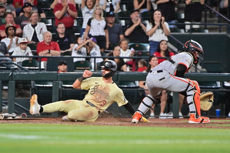 Jun 4, 2024; Phoenix, Arizona, USA;  Arizona Diamondbacks shortstop Blaze Alexander (9) scores as San Francisco Giants catcher Patrick Bailey (14) waits for the ball in the seventh inning at Chase Field. Mandatory Credit: Matt Kartozian-USA TODAY Sports