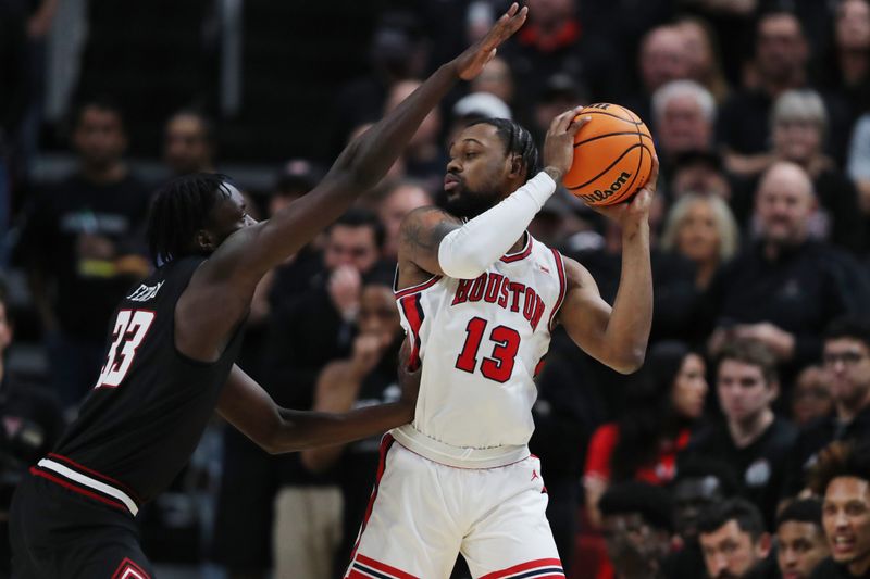 Feb 24, 2025; Lubbock, Texas, USA;  Houston Cougars forward J’Wan Roberts (13) keeps the ball from Texas Tech Red Raiders forward Federiko Federiko (33) in the first half at United Supermarkets Arena. Mandatory Credit: Michael C. Johnson-Imagn Images