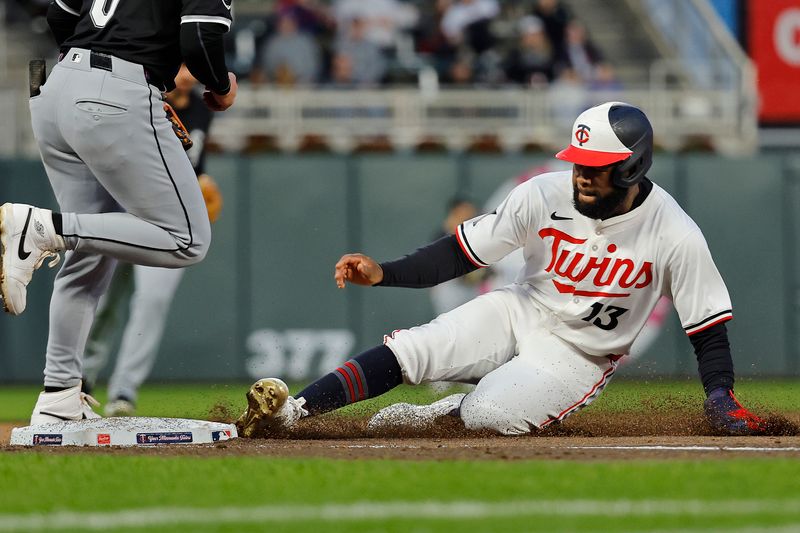 Apr 24, 2024; Minneapolis, Minnesota, USA; Minnesota Twins right fielder Manny Margot (13) slides into third base after tagging up from second on a fly ball against the Chicago White Sox in the fifth inning at Target Field. Mandatory Credit: Bruce Kluckhohn-USA TODAY Sports