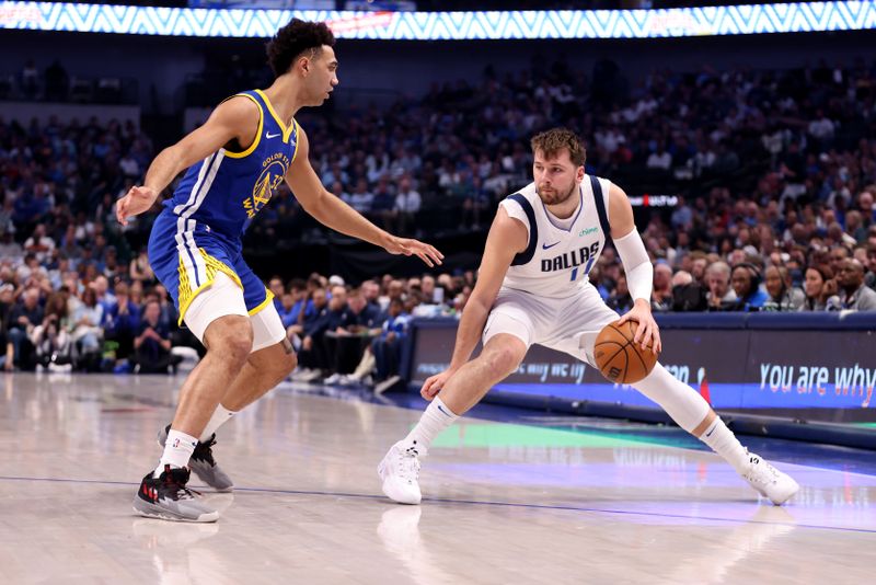 DALLAS, TEXAS - MARCH 13: Luka Doncic #77 of the Dallas Mavericks dribbles the ball against Trayce Jackson-Davis #32 of the Golden State Warriors in the first half at American Airlines Center on March 13, 2024 in Dallas, Texas. NOTE TO USER: User expressly acknowledges and agrees that, by downloading and or using this photograph, User is consenting to the terms and conditions of the Getty Images License Agreement. (Photo by Tim Heitman/Getty Images)