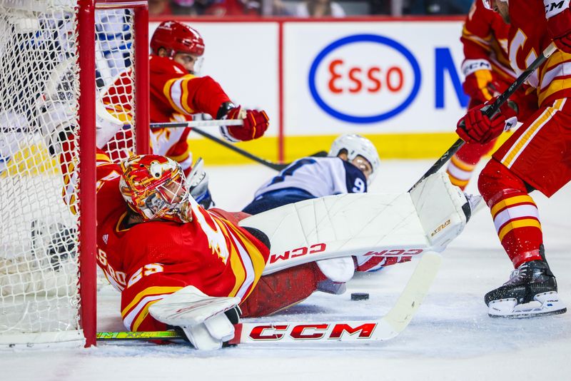 Feb 19, 2024; Calgary, Alberta, CAN; Calgary Flames goaltender Jacob Markstrom (25) makes a save against the Winnipeg Jets during the first period at Scotiabank Saddledome. Mandatory Credit: Sergei Belski-USA TODAY Sports