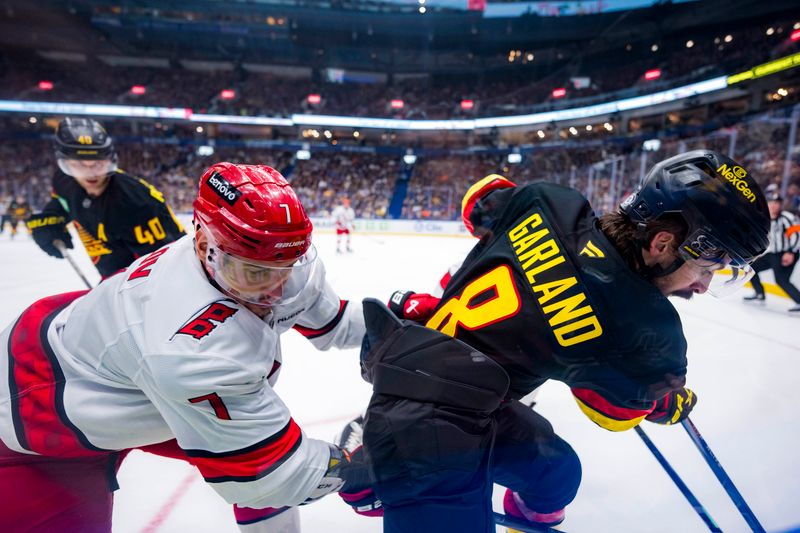 Oct 28, 2024; Vancouver, British Columbia, CAN; Carolina Hurricanes defenseman Dmitry Orlov (7) battles with Vancouver Canucks forward Conor Garland (8) during the third period at Rogers Arena. Mandatory Credit: Bob Frid-Imagn Images