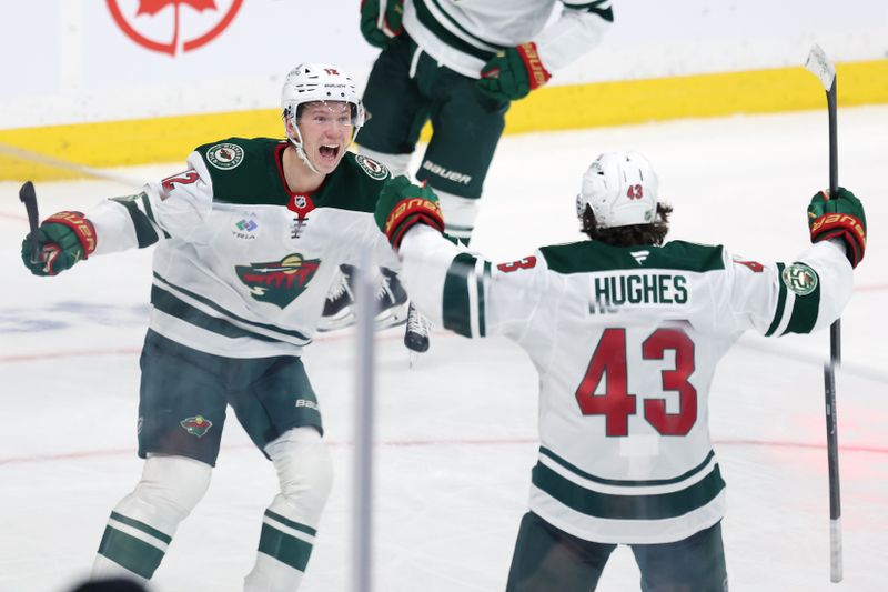 Dec 27, 2025; Winnipeg, Manitoba, CAN; Minnesota Wild left wing Matt Boldy (12) celebrates his overtime goal against the Winnipeg Jets with Minnesota Wild defenseman Quinn Hughes (43) at Canada Life Centre. Mandatory Credit: James Carey Lauder-Imagn Images