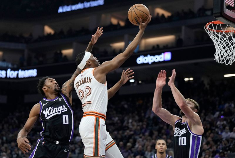 SACRAMENTO, CALIFORNIA - MARCH 07: Malaki Branham #22 of the San Antonio Spurs shoots over Malik Monk #0 and Domantas Sabonis #10 of the Sacramento Kings during the first half at Golden 1 Center on March 07, 2024 in Sacramento, California. NOTE TO USER: User expressly acknowledges and agrees that, by downloading and or using this photograph, User is consenting to the terms and conditions of the Getty Images License Agreement. (Photo by Thearon W. Henderson/Getty Images)