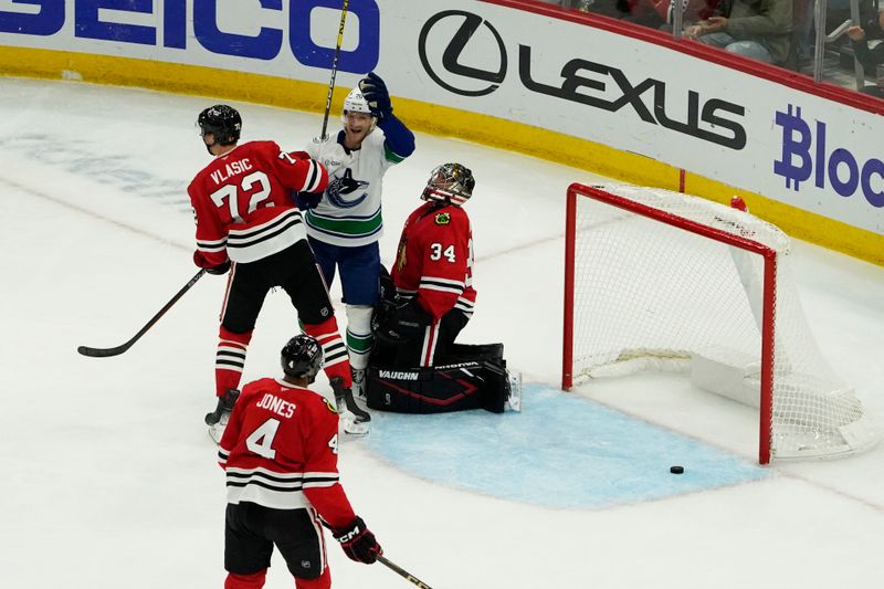 Oct 22, 2024; Chicago, Illinois, USA; Vancouver Canucks left wing Danton Heinen (20) scores a goal on Chicago Blackhawks goaltender Petr Mrazek (34) during the first period at United Center. Mandatory Credit: David Banks-Imagn Images