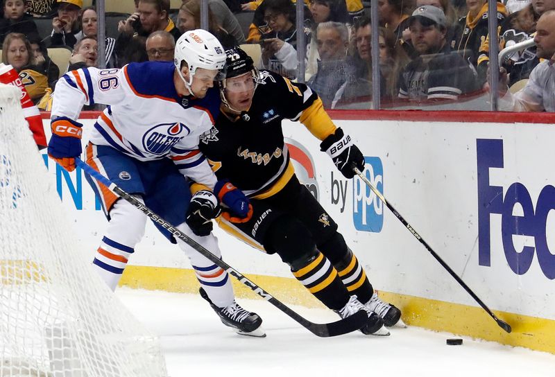 Feb 23, 2023; Pittsburgh, Pennsylvania, USA; Pittsburgh Penguins center Jeff Carter (77) moves the puck against Edmonton Oilers defenseman Philip Broberg (86) during the first period at PPG Paints Arena. Mandatory Credit: Charles LeClaire-USA TODAY Sports