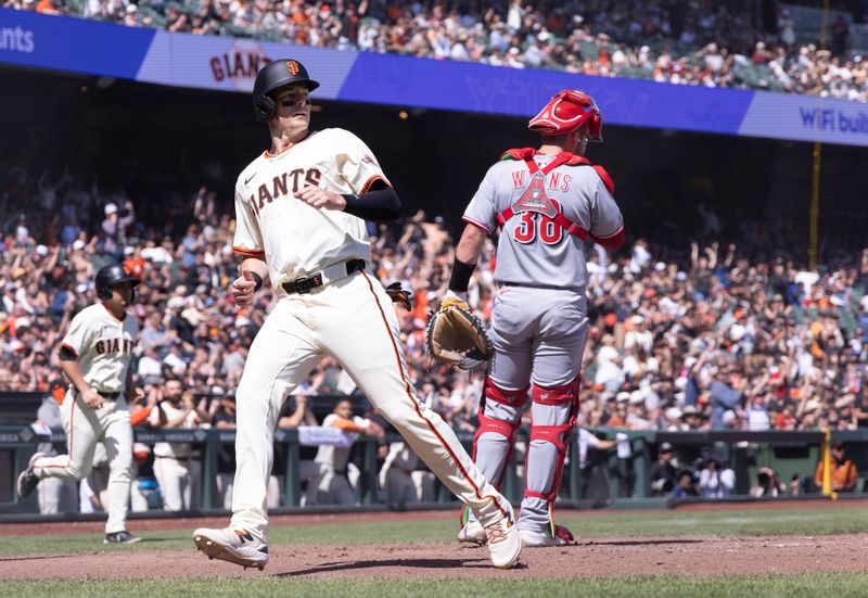 Apr 9, 2025; San Francisco, California, USA;  San Francisco Giants right fielder Mike Yastrzemski (5) scores a run behind Cincinnati Reds catcher Austin Wynns (38) during the sixth inning at Oracle Park. Mandatory Credit: Kelley L Cox-Imagn Images