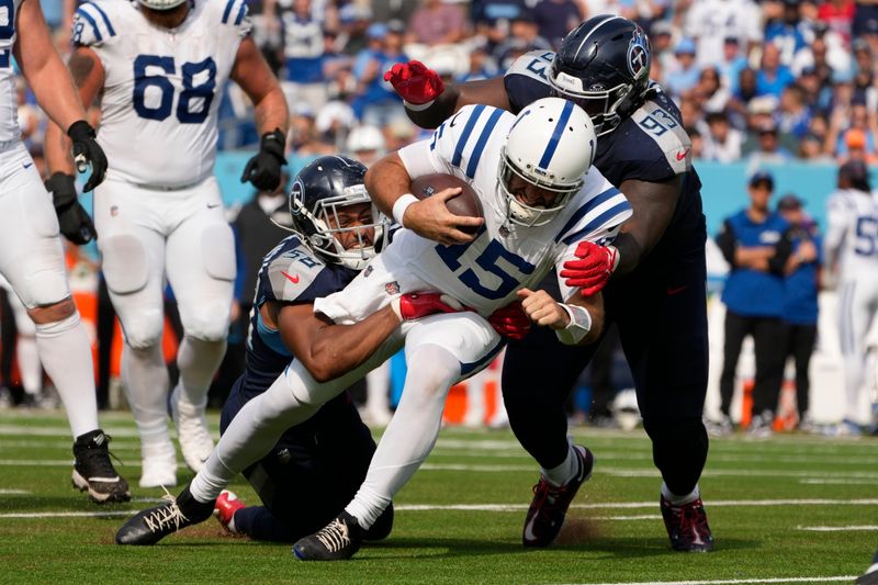 Indianapolis Colts quarterback Joe Flacco (15) is tackled by Tennessee Titans' Harold Landry III (58) and T'Vondre Sweat (93) during the second half of an NFL football game, Sunday, Oct. 13, 2024, in Nashville, Tenn. (AP Photo/George Walker IV)