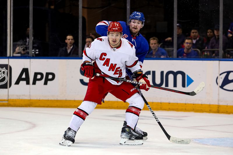 Jan 2, 2024; New York, New York, USA; New York Rangers forward Alexis Lafreniere (13) and Carolina Hurricanes defenseman Dmitry Orlov (7) battle for position during the first period at Madison Square Garden. Mandatory Credit: Danny Wild-USA TODAY Sports