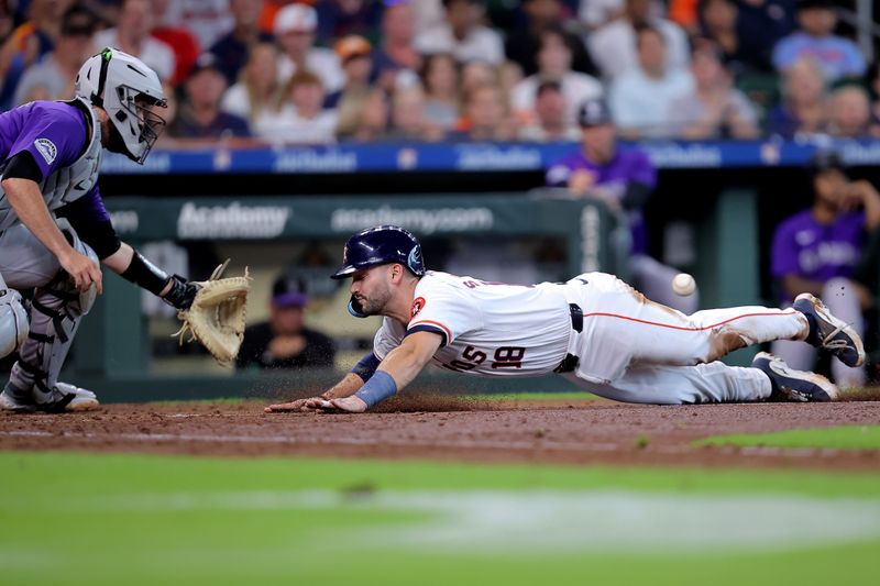 Jun 26, 2024; Houston, Texas, USA; Houston Astros catcher Cesar Salazar (18) slides into home plate to score a run against the Colorado Rockies during the fifth inning at Minute Maid Park. Mandatory Credit: Erik Williams-USA TODAY Sports