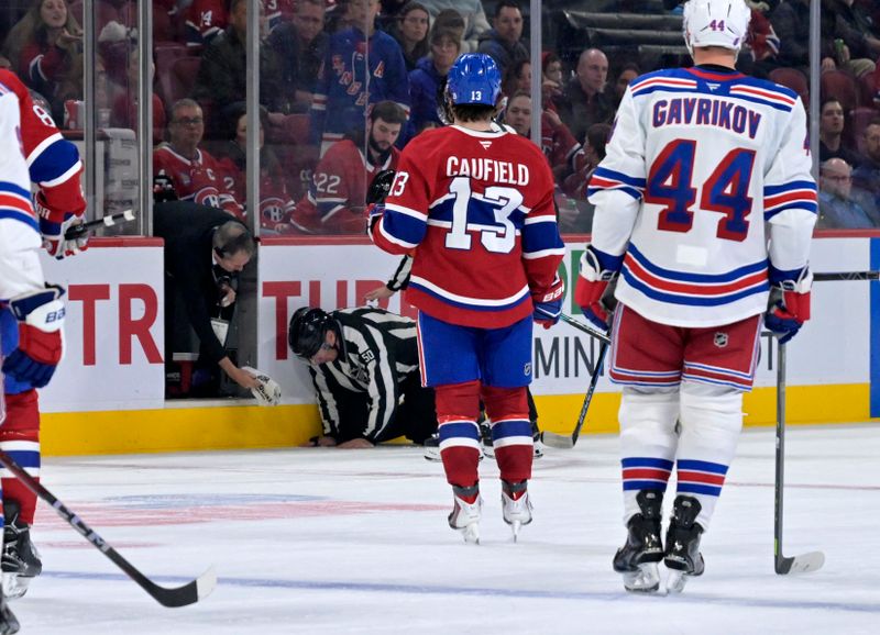 Oct 18, 2025; Montreal, Quebec, CAN; A NHL official looks over linesman Scott Cherrey (50) after his injury during the third period of the game between the New York Rangers and Montreal Canadiens at the Bell Centre. Mandatory Credit: Eric Bolte-Imagn Images