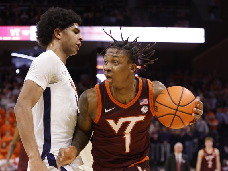 Feb 1, 2025; Charlottesville, Virginia, USA; Virginia Tech Hokies forward Tobi Lawal (1) controls the ball as Virginia Cavaliers forward Jacob Cofie (5) defends in the first half at John Paul Jones Arena. Mandatory Credit: Amber Searls-Imagn Images