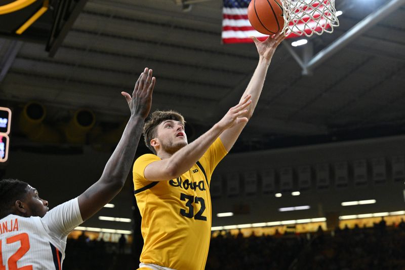 Mar 10, 2024; Iowa City, Iowa, USA; Iowa Hawkeyes forward Owen Freeman (32) goes to the basket as Illinois Fighting Illini forward Dain Dainja (42) defends during the second half at Carver-Hawkeye Arena. Mandatory Credit: Jeffrey Becker-USA TODAY Sports