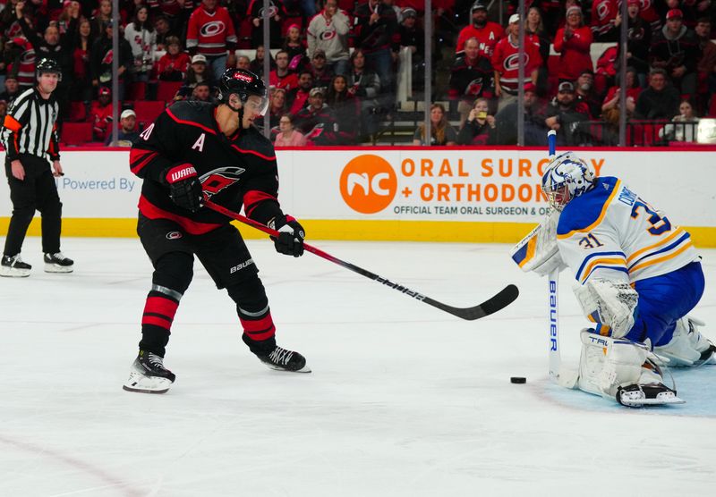 Dec 2, 2023; Raleigh, North Carolina, USA; Buffalo Sabres goaltender Eric Comrie (31) stops the scoring attempt by Carolina Hurricanes center Sebastian Aho (20) during the third period at PNC Arena. Mandatory Credit: James Guillory-USA TODAY Sports