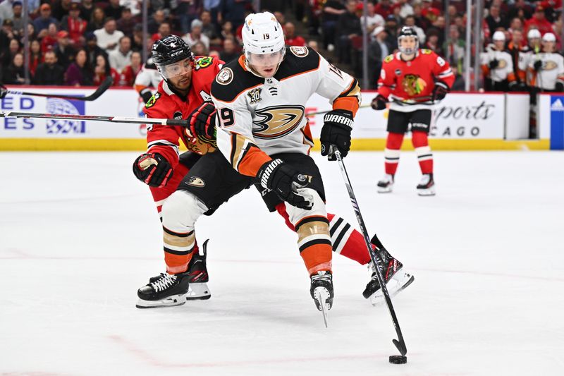 Mar 12, 2024; Chicago, Illinois, USA; Anaheim Ducks forward Troy Terry (19) maintains control of the puck while being defended by Chicago Blackhawks defenseman Seth Jones (4) in the second period at United Center. Mandatory Credit: Jamie Sabau-USA TODAY Sports