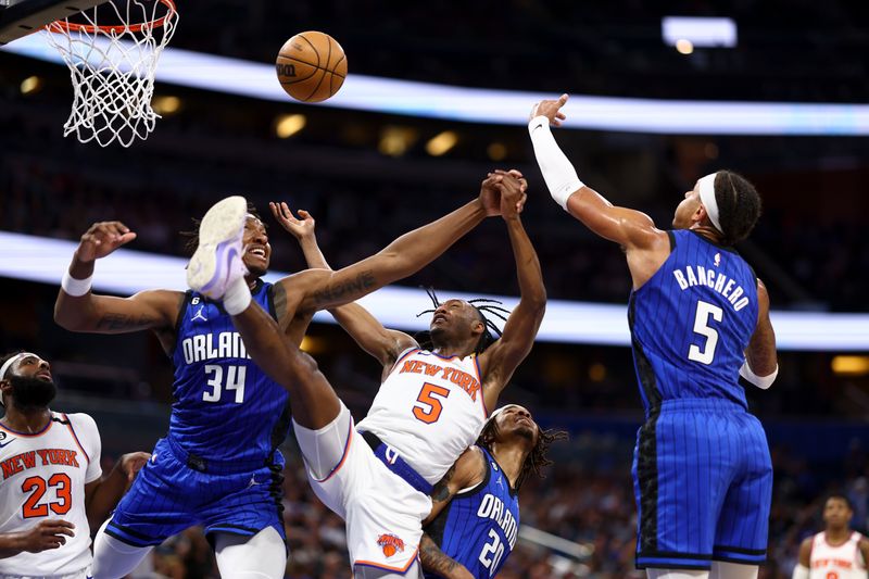 ORLANDO, FLORIDA - MARCH 23: Immanuel Quickley #5 of the New York Knicks battles for the ball against Wendell Carter Jr. #34 and Paolo Banchero #5 of the Orlando Magic during the second quarter at Amway Center on March 23, 2023 in Orlando, Florida. NOTE TO USER: User expressly acknowledges and agrees that, by downloading and or using this photograph, User is consenting to the terms and conditions of the Getty Images License Agreement. (Photo by Douglas P. DeFelice/Getty Images)