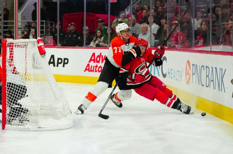 Mar 21, 2024; Raleigh, North Carolina, USA; Philadelphia Flyers defenseman Erik Johnson (77) checks Carolina Hurricanes left wing Jake Guentzel (59) during the third period at PNC Arena. Mandatory Credit: James Guillory-USA TODAY Sports