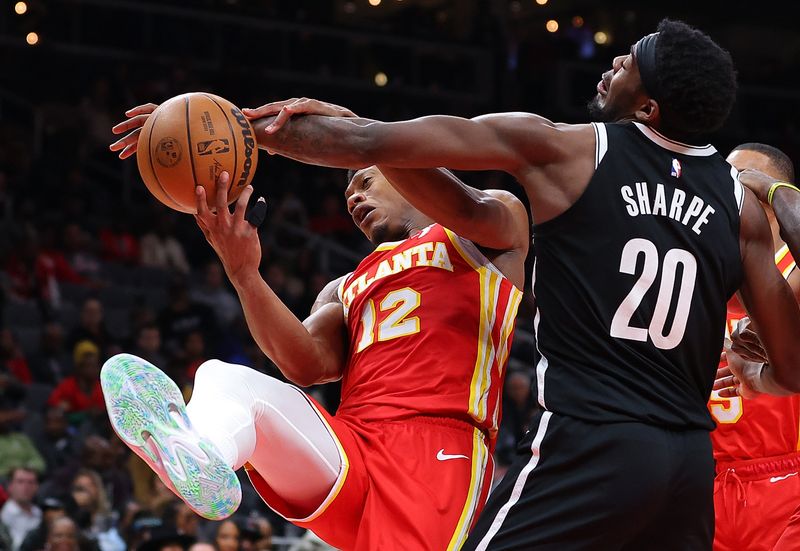 ATLANTA, GEORGIA - DECEMBER 06:  De'Andre Hunter #12 of the Atlanta Hawks battles for a rebound against Day'Ron Sharpe #20 of the Brooklyn Nets during the fourth quarter at State Farm Arena on December 06, 2023 in Atlanta, Georgia.  NOTE TO USER: User expressly acknowledges and agrees that, by downloading and/or using this photograph, user is consenting to the terms and conditions of the Getty Images License Agreement.  (Photo by Kevin C. Cox/Getty Images)