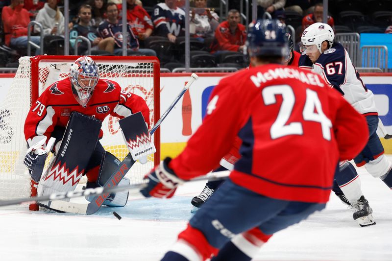 Sep 27, 2024; Washington, District of Columbia, USA; Washington Capitals goaltender Charlie Lindgren (79) makes a save on Columbus Blue Jackets left wing James Malatesta (67) in the second period at Capital One Arena. Mandatory Credit: Geoff Burke-Imagn Images