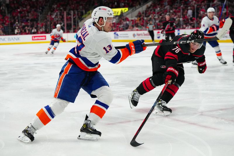 Apr 20, 2024; Raleigh, North Carolina, USA; New York Islanders center Mathew Barzal (13) take s shot past Carolina Hurricanes defenseman Brady Skjei (76) during the second period in game one of the first round of the 2024 Stanley Cup Playoffs at PNC Arena. Mandatory Credit: James Guillory-USA TODAY Sports