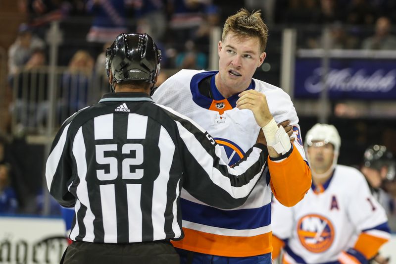 Sep 26, 2023; New York, New York, USA;  New York Islanders left wing Ross Johnston (32) is held by an official after fighting in the second period against the New York Rangers at Madison Square Garden. Mandatory Credit: Wendell Cruz-USA TODAY Sports