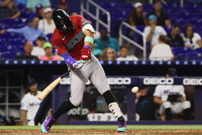 Aug 19, 2024; Miami, Florida, USA; Arizona Diamondbacks left fielder Lourdes Gurriel Jr. (12) hits a single against the Miami Marlins during the seventh inning at loanDepot Park. Mandatory Credit: Sam Navarro-USA TODAY Sports