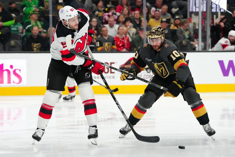 Mar 17, 2024; Las Vegas, Nevada, USA; New Jersey Devils defenseman Nick DeSimone (57) clears the puck away from Vegas Golden Knights center Nicolas Roy (10) during the third period at T-Mobile Arena. Mandatory Credit: Stephen R. Sylvanie-USA TODAY Sports