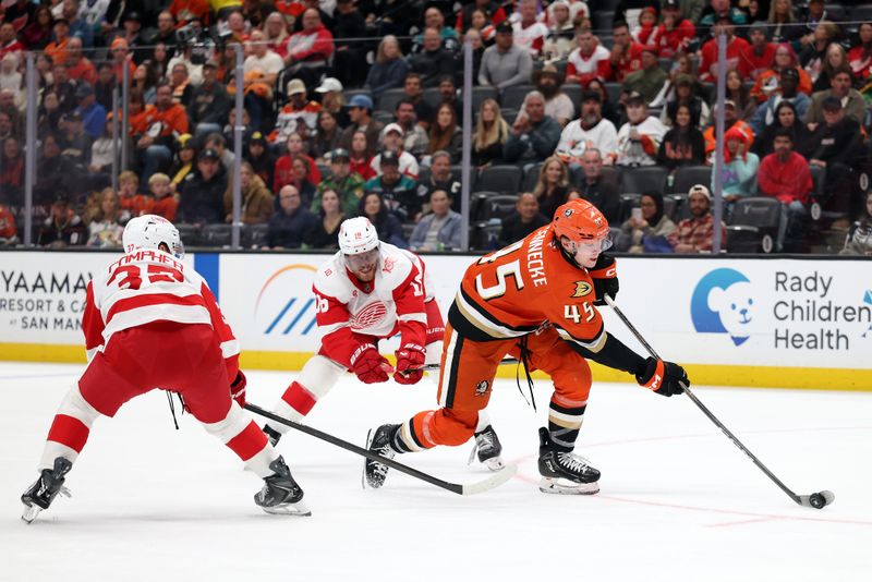 Oct 31, 2025; Anaheim, California, USA;  Anaheim Ducks right wing Beckett Sennecke (45) controls the puck between Detroit Red Wings left wing J.T. Compher (37) and center Andrew Copp (18) during the second period at Honda Center. Mandatory Credit: Kiyoshi Mio-Imagn Images