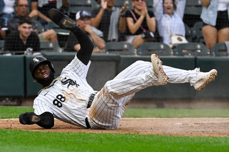 Jul 27, 2024; Chicago, Illinois, USA;  Chicago White Sox outfielder Luis Robert Jr. (88) slides safely into home plate against the Seattle Mariners during the third inning at Guaranteed Rate Field. Mandatory Credit: Matt Marton-USA TODAY Sports