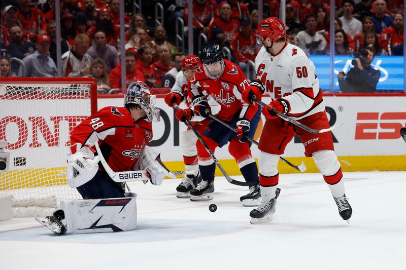 May 6, 2025; Washington, District of Columbia, USA; Washington Capitals goaltender Logan Thompson (48) makes a save on Carolina Hurricanes left wing Eric Robinson (50) in the second period in game one of the second round of the 2025 Stanley Cup Playoffs at Capital One Arena. Mandatory Credit: Geoff Burke-Imagn Images