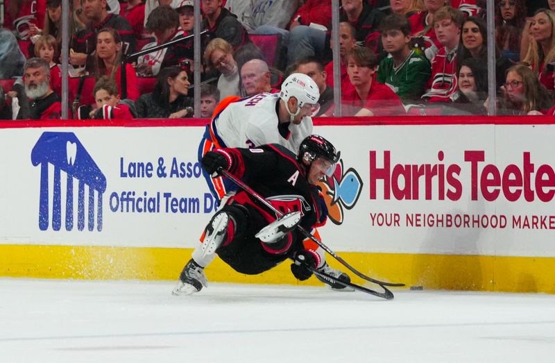 Apr 20, 2024; Raleigh, North Carolina, USA; New York Islanders defenseman Adam Pelech (3) checks Carolina Hurricanes center Sebastian Aho (20) during the second period in game one of the first round of the 2024 Stanley Cup Playoffs at PNC Arena. Mandatory Credit: James Guillory-USA TODAY Sports