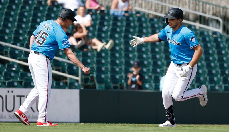 Feb 25, 2025; Jupiter, Florida, USA;  Miami Marlins first baseman Matt Mervis (36) celebrates with third base coach Blake Lalli (45) after hitting a home run against the Washington Nationals during the second inning at Roger Dean Chevrolet Stadium. Mandatory Credit: Rhona Wise-Imagn Image 