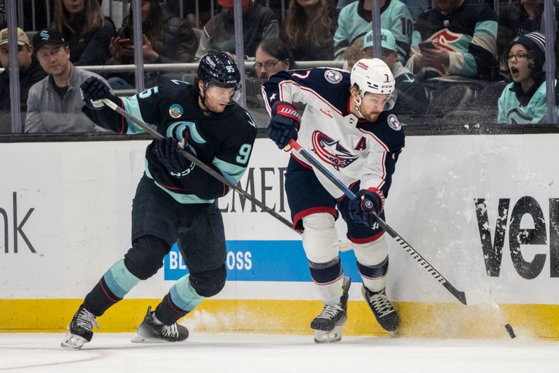 Jan 28, 2024; Seattle, Washington, USA; Columbus Blue Jackets forward Sean Kuraly (7) and Seattle Kraken forward Andre Burakovsky (95) battle for the puck during the first period at Climate Pledge Arena. Mandatory Credit: Stephen Brashear-USA TODAY Sports