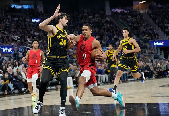 SAN FRANCISCO, CALIFORNIA - DECEMBER 23: Malcolm Brogdon #11 of the Portland Trail Blazers drives to the basket on Dario Saric #20 of the Golden State Warriors during the first half of an NBA basketball game at Chase Center on December 23, 2023 in San Francisco, California. NOTE TO USER: User expressly acknowledges and agrees that, by downloading and or using this photograph, User is consenting to the terms and conditions of the Getty Images License Agreement. (Photo by Thearon W. Henderson/Getty Images)