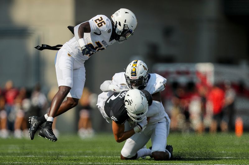 Sep 11, 2021; Cincinnati, Ohio, USA; Murray State Racers cornerback Quinaz Turner (4) tackles Cincinnati Bearcats wide receiver Alec Pierce (12) while safety Cortez Roberts (26) avoids the tackle in the first half at Nippert Stadium. Mandatory Credit: Katie Stratman-USA TODAY Sports