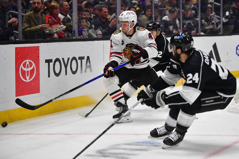 Apr 18, 2024; Los Angeles, California, USA; Chicago Blackhawks center Frank Nazar (91) plays for the puck against Los Angeles Kings left wing Trevor Moore (12) and center Phillip Danault (24) during the second period at Crypto.com Arena. Mandatory Credit: Gary A. Vasquez-USA TODAY Sports