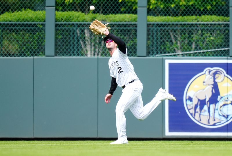 May 9, 2024; Denver, Colorado, USA; Colorado Rockies outfielder Sean Bouchard (12) prepares to field the ball in the seventh inning against the San Francisco Giants at Coors Field. Mandatory Credit: Ron Chenoy-USA TODAY Sports