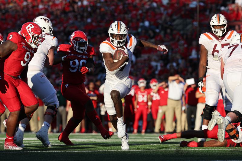 Sep 16, 2023; Piscataway, New Jersey, USA; Virginia Tech Hokies wide receiver Da'Quan Felton (9) gains yards after a catch during the second half in front of Rutgers Scarlet Knights defensive lineman Isaiah Iton (9) and defensive lineman Rene Konga (90) at SHI Stadium. Mandatory Credit: Vincent Carchietta-USA TODAY Sports