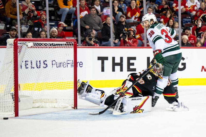 Nov 23, 2024; Calgary, Alberta, CAN; Minnesota Wild right wing Ryan Hartman (38) runs into Calgary Flames goaltender Daniel Vladar (80) after missing in the shootout at Scotiabank Saddledome. Mandatory Credit: Brett Holmes-Imagn Images