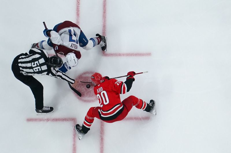 Dec 5, 2024; Raleigh, North Carolina, USA;  Colorado Avalanche center Parker Kelly (17) takes a face off against Carolina Hurricanes center Sebastian Aho (20) during the second period at Lenovo Center. Mandatory Credit: James Guillory-Imagn Images