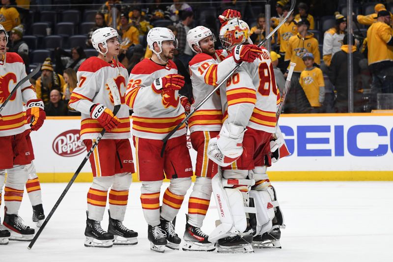 Jan 4, 2024; Nashville, Tennessee, USA; Calgary Flames goaltender Dan Vladar (80) is congratulated by center Jonathan Huberdeau (10) and teammates after a win against the Nashville Predators at Bridgestone Arena. Mandatory Credit: Christopher Hanewinckel-USA TODAY Sports