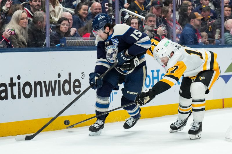 Jan 4, 2026; Columbus, Ohio, USA;  Columbus Blue Jackets defenseman Dante Fabbro (15) skates with the puck against Pittsburgh Penguins right wing Bryan Rust (17) in the second period at Nationwide Arena. Mandatory Credit: Aaron Doster-Imagn Images