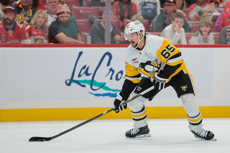 Oct 23, 2025; Sunrise, Florida, USA; Pittsburgh Penguins defenseman Erik Karlsson (65) moves the puck against the Florida Panthers during the first period at Amerant Bank Arena. Mandatory Credit: Sam Navarro-Imagn Images