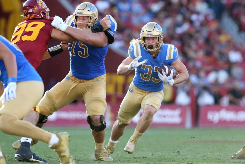 Nov 18, 2023; Los Angeles, California, USA; UCLA Bruins running back Carson Steele (33) runs during the fourth quarter against the USC Trojans at United Airlines Field at Los Angeles Memorial Coliseum. Mandatory Credit: Jason Parkhurst-USA TODAY Sports