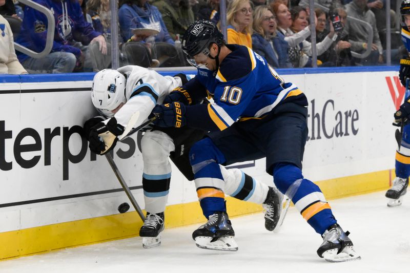 Nov 7, 2024; St. Louis, Missouri, USA; St. Louis Blues center Brayden Schenn (10) checks Utah Hockey Club defenseman Michael Kesselring (7) during the second  period at Enterprise Center. Mandatory Credit: Jeff Le-Imagn Images