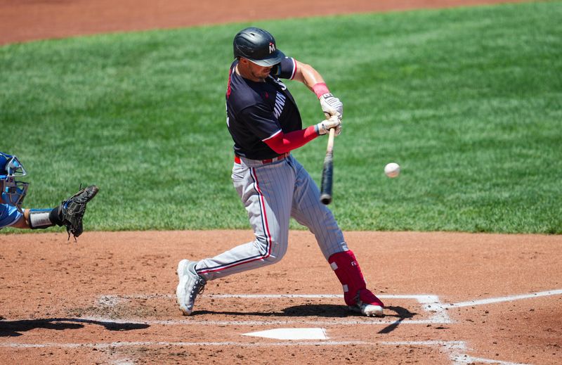 Jul 30, 2023; Kansas City, Missouri, USA; Minnesota Twins third baseman Kyle Farmer (12) hits a single against the Kansas City Royals during the fourth inning at Kauffman Stadium. Mandatory Credit: Jay Biggerstaff-USA TODAY Sports