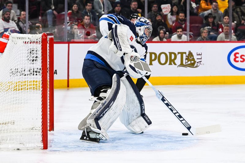 Jan 17, 2023; Montreal, Quebec, CAN; Winnipeg Jets goalie Connor Hellebuyck (37) intercepts the puck in front of his net against the Montreal Canadiens during the second period at Bell Centre. Mandatory Credit: David Kirouac-USA TODAY Sports