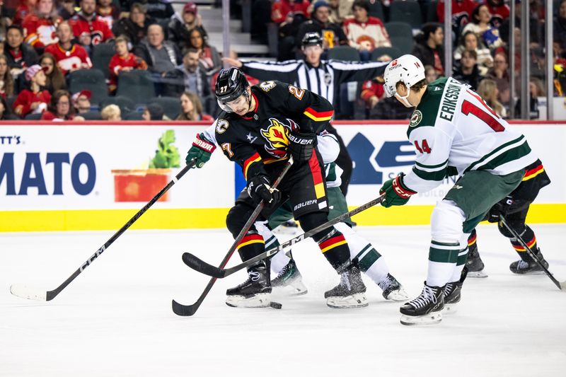 Nov 23, 2024; Calgary, Alberta, CAN; Calgary Flames right wing Matt Coronato (27) skates with the puck against Minnesota Wild center Joel Eriksson Ek (14) during the second period at Scotiabank Saddledome. Mandatory Credit: Brett Holmes-Imagn Images