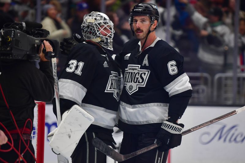 Jan 20, 2026; Los Angeles, California, USA; Los Angeles Kings goaltender Anton Forsberg (31) and defenseman Joel Edmundson (6) celebrate the victory against the New York Rangers at Crypto.com Arena. Mandatory Credit: Gary A. Vasquez-Imagn Images